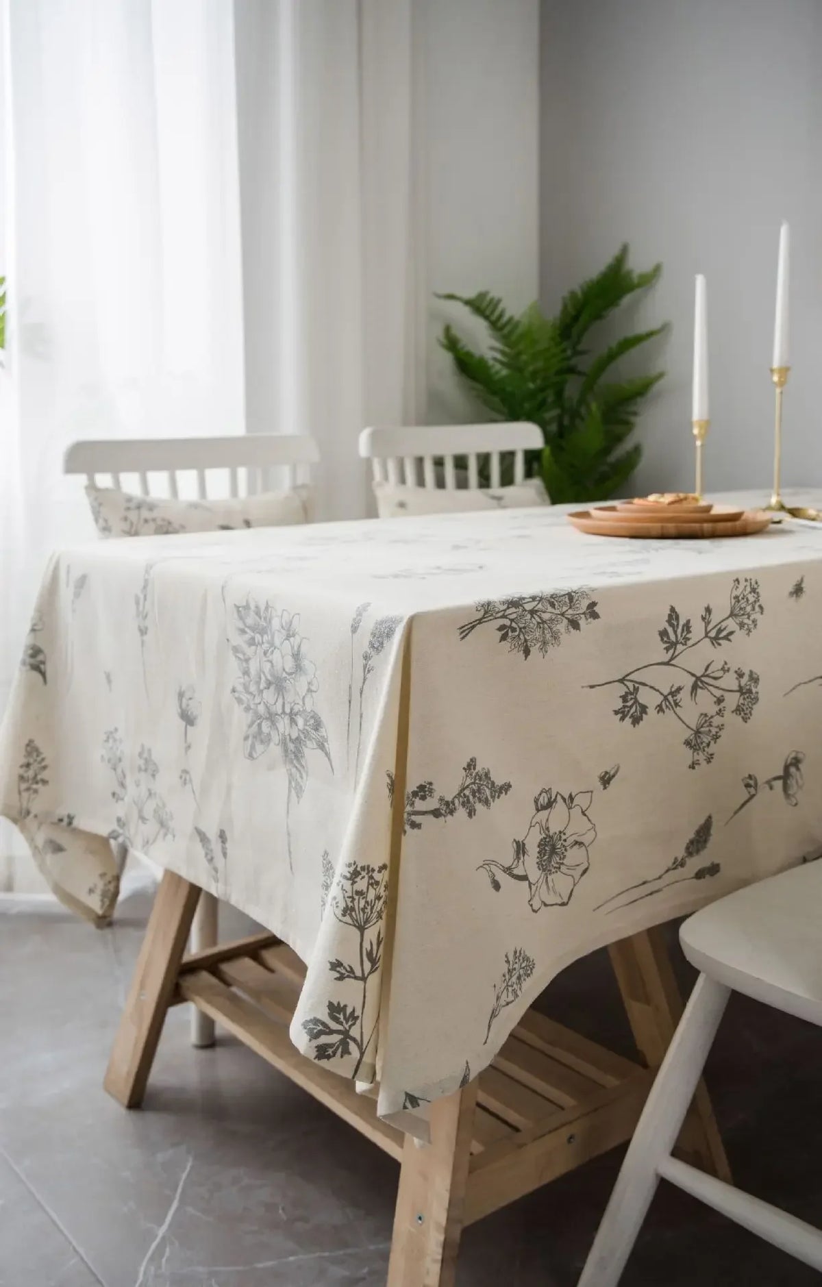A light beige cotton-linen tablecloth featuring a rustic fern print on a wooden table.