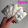 A hand holds five white RFID blocking card sleeves with geometric patterns.