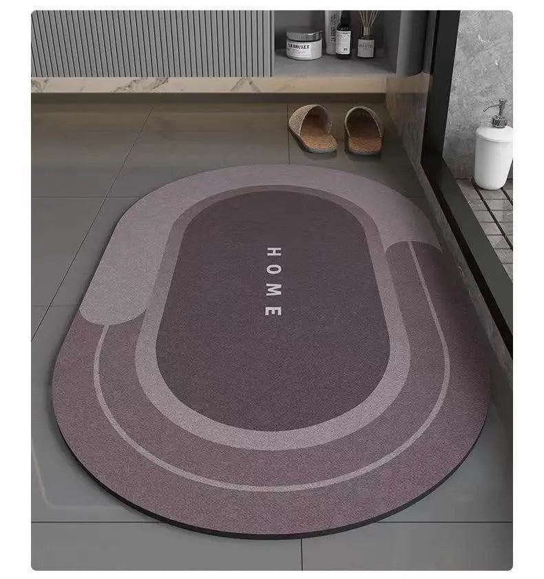 A round, gray bath mat with concentric rings and the word HOME printed on it, placed on a tiled floor.