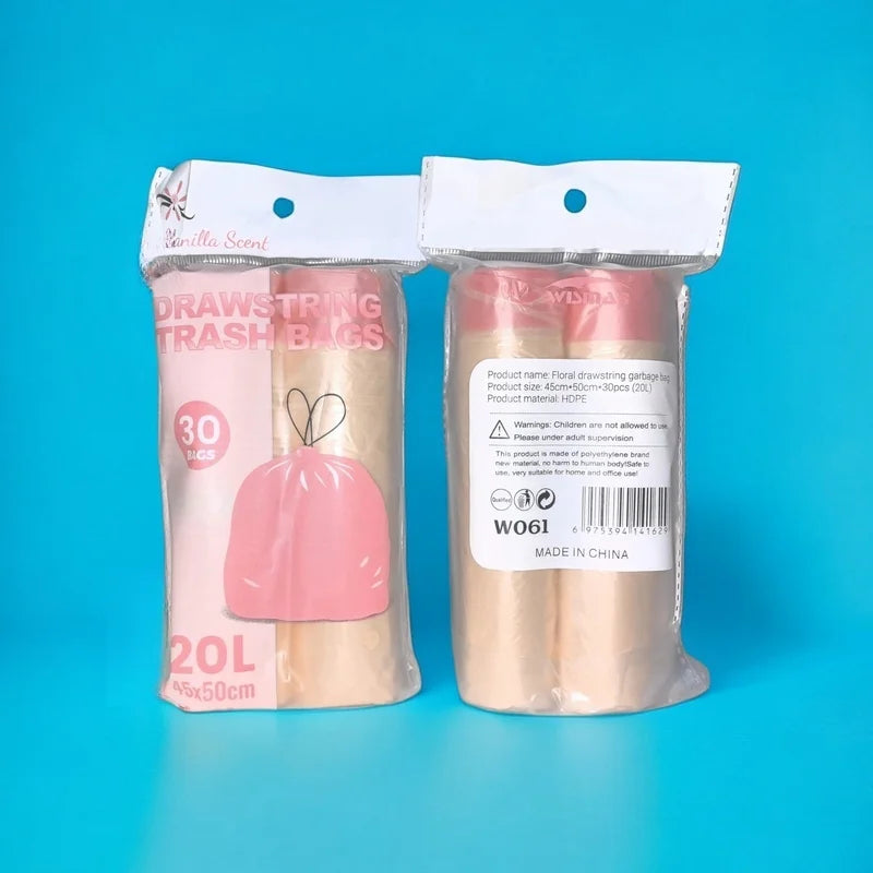 A package of pink scented drawstring trash bags with handles and a roll of beige scented material.