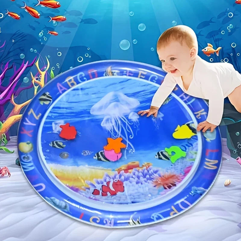 A baby is interacting with a blue plastic plate featuring colorful fish and sea life for tummy time and sensory development.