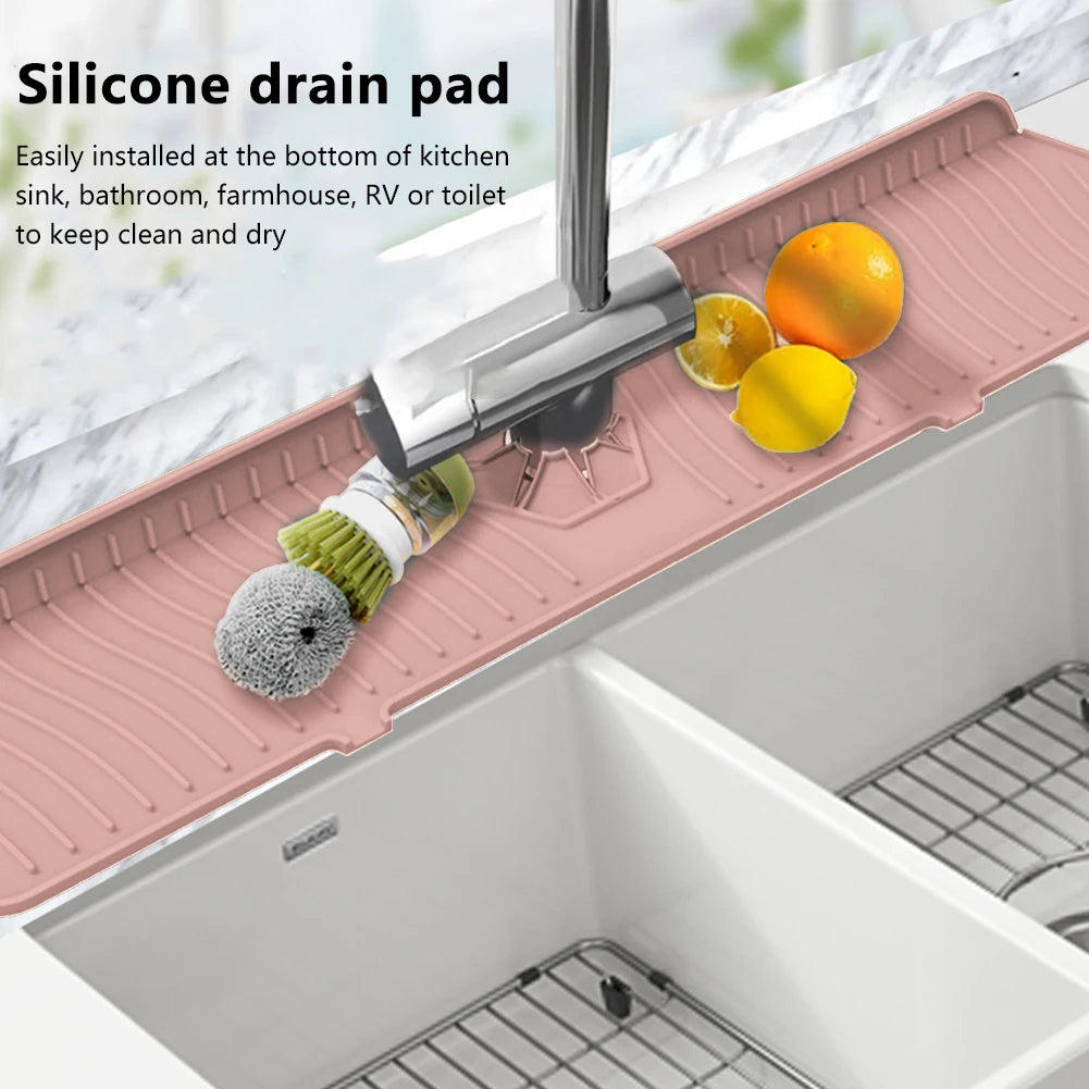 A silicone drain pad is installed at the bottom of a kitchen sink, with fruit resting on it.