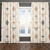 Light beige curtains with a boho tribal pattern featuring repeating bull skulls and geometric designs filtering light through
