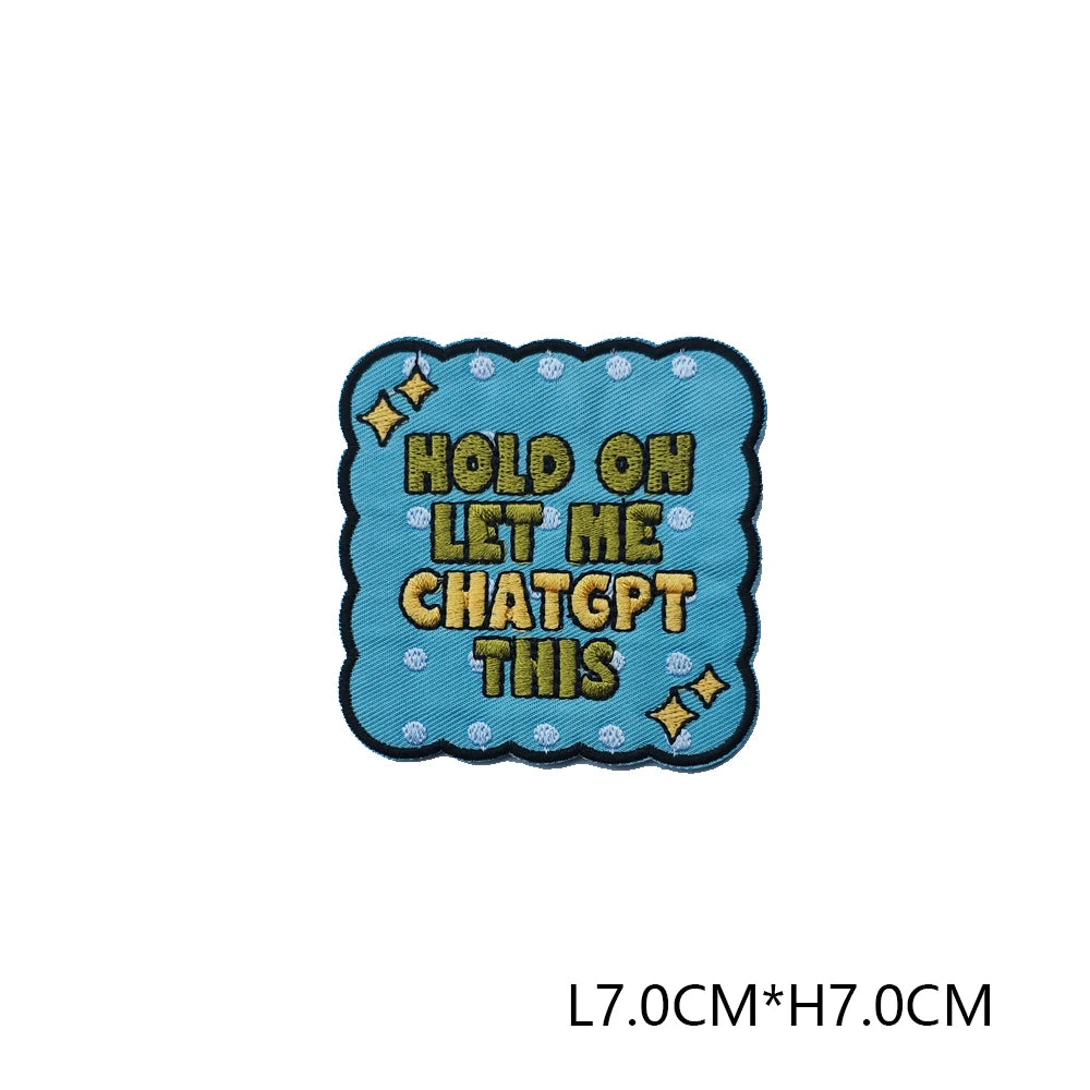 A teal embroidered patch with yellow text that reads Hold on let me chatgpt this