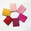 A collection of six genuine leather slim card holder wallets in various shades of pink and magenta arranged in a circle.