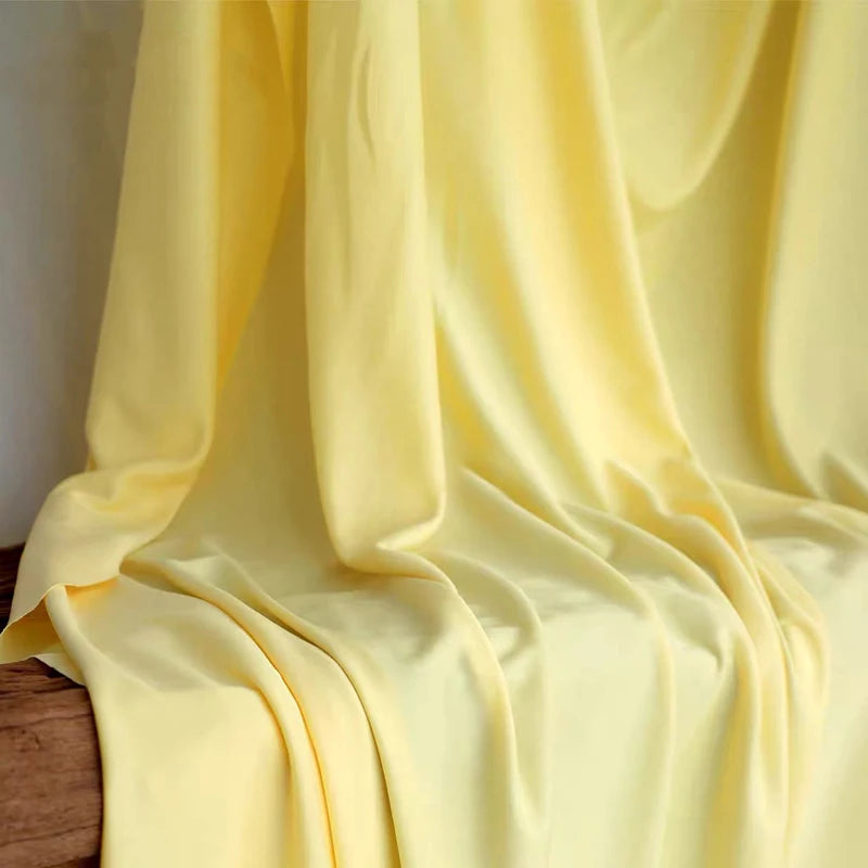Flowing yellow stretch jersey fabric draped elegantly for decor and backdrops