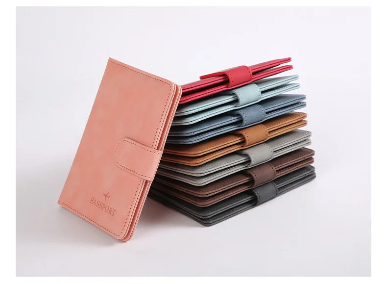 Une pile de porte-passeports en cuir de différentes couleurs, rouge, bleu, marron et gris.