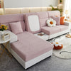 A light pink elegant jacquard sofa slipcover with white cushions and orange accents in a modern living room setting.