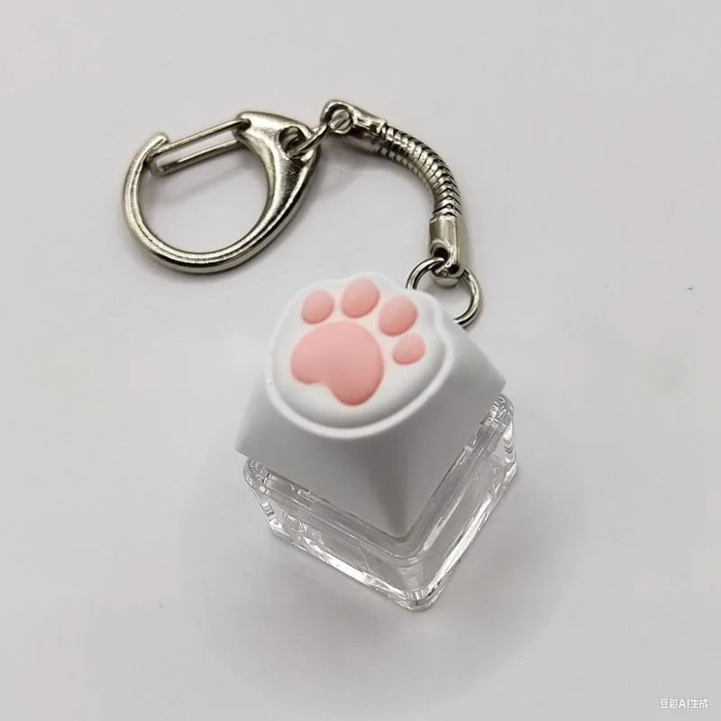 A white silicone paw print keychain with a silver clasp and a clear plastic base.