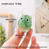 A hand holds a handcrafted crystal owl figurine with a natural crushed stone finish, showing its size and detail.