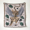 A woven throw blanket featuring a bohemian design with tiger and leaf motifs in muted earth tones.