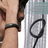 A close-up of a hand wearing a black braided leather cord bracelet against a gray striped background.