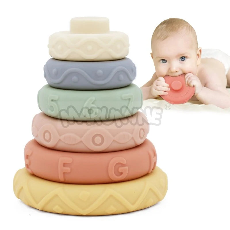 An 8-piece set of soft silicone stacking rings in various pastel colors stacked vertically with a baby