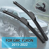A pair of black windshield wiper blades for a GMC Yukon, shown against a blurred vehicle background.