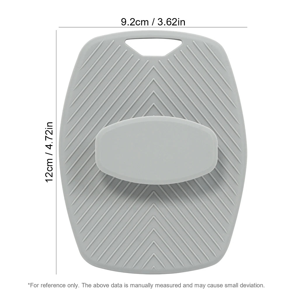 A gray silicone body scrubber and massage brush with a textured surface and a central oval pad.