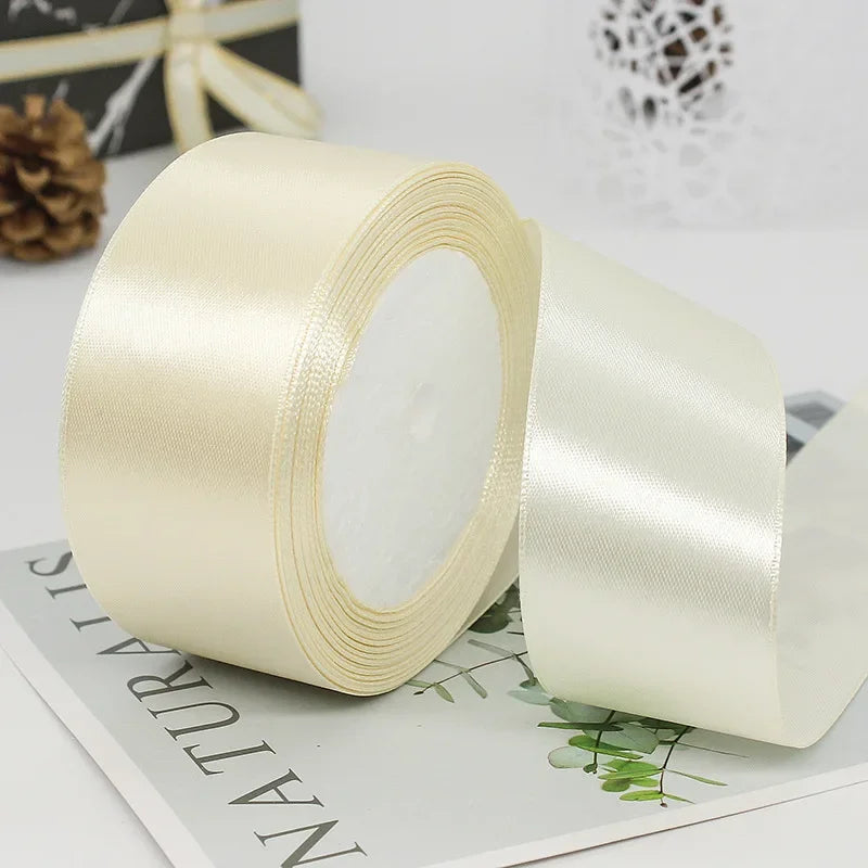 A roll of cream or ivory satin ribbon used for gift wrapping and DIY crafts.