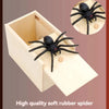 A wooden box containing a black rubber spider and another spider on a circular background.