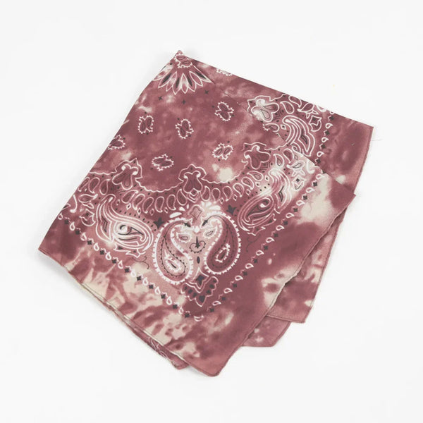 A folded bandana featuring a paisley pattern in shades of dusty rose and white.