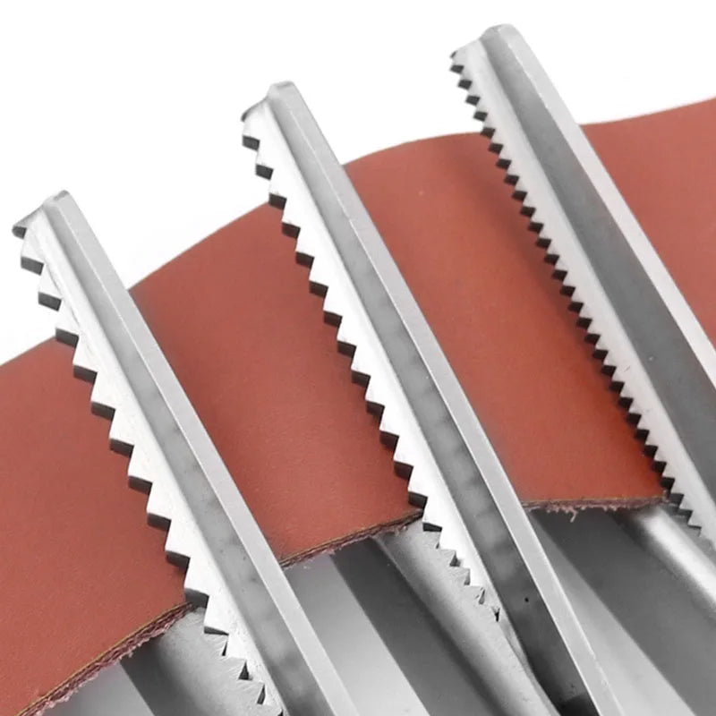Close-up view of stainless steel pinking shears with serrated edges against a reddish fabric background.