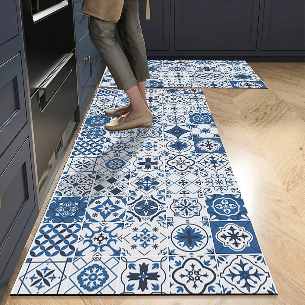 A rectangular blue and white patterned non-slip absorbent floor mat placed on a light wood floor.