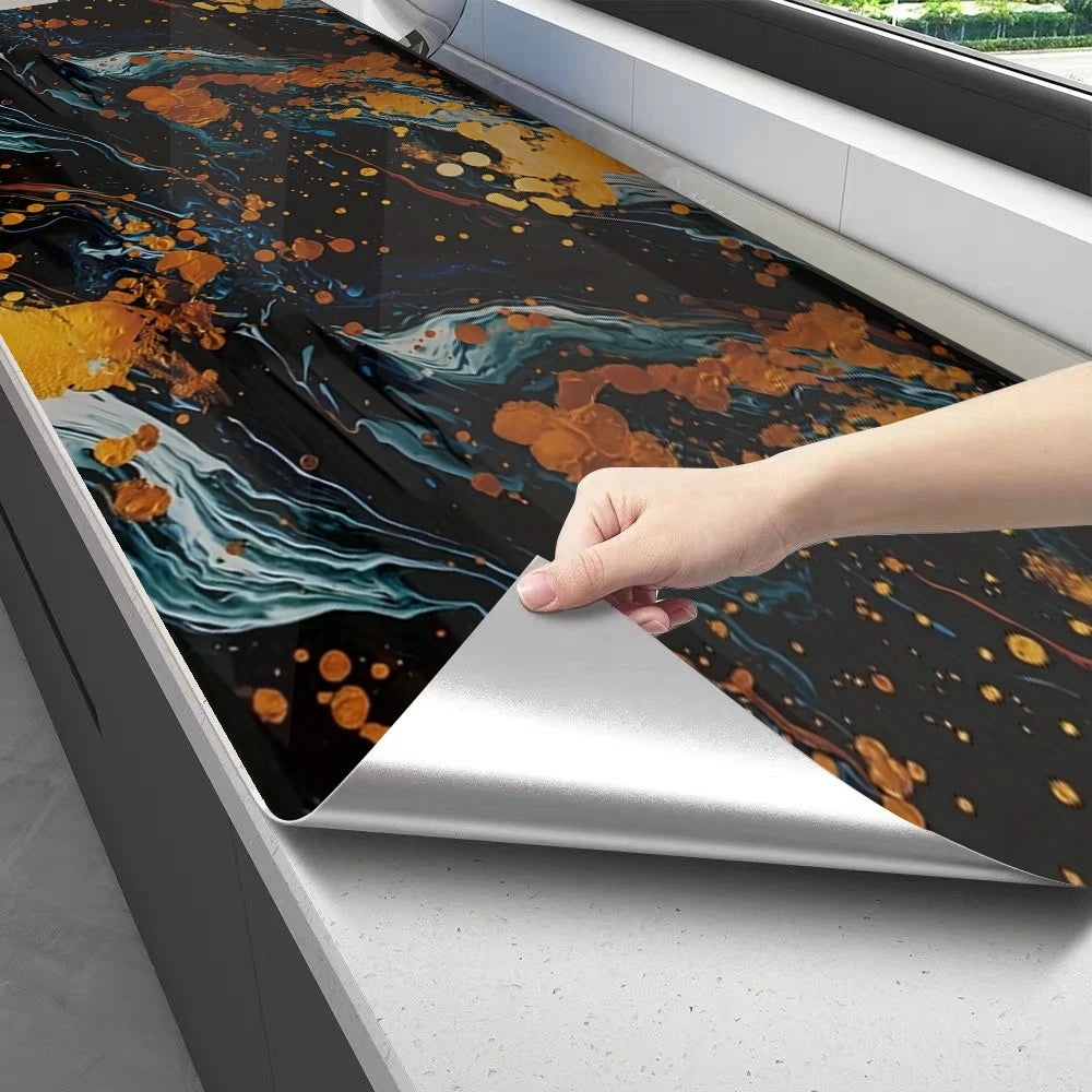 A hand is peeling off a sheet of self-adhesive marble contact paper featuring an abstract dark blue and gold marbled design.