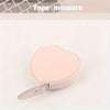 A pink PU leather heart-shaped tape measure is shown against a white background.
