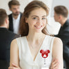 A smiling woman wearing a white top with a red Mickey Mouse silhouette badge reel on her chest.