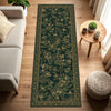 A long, dark green botanical runner rug with gold accents laid on a light wood floor.