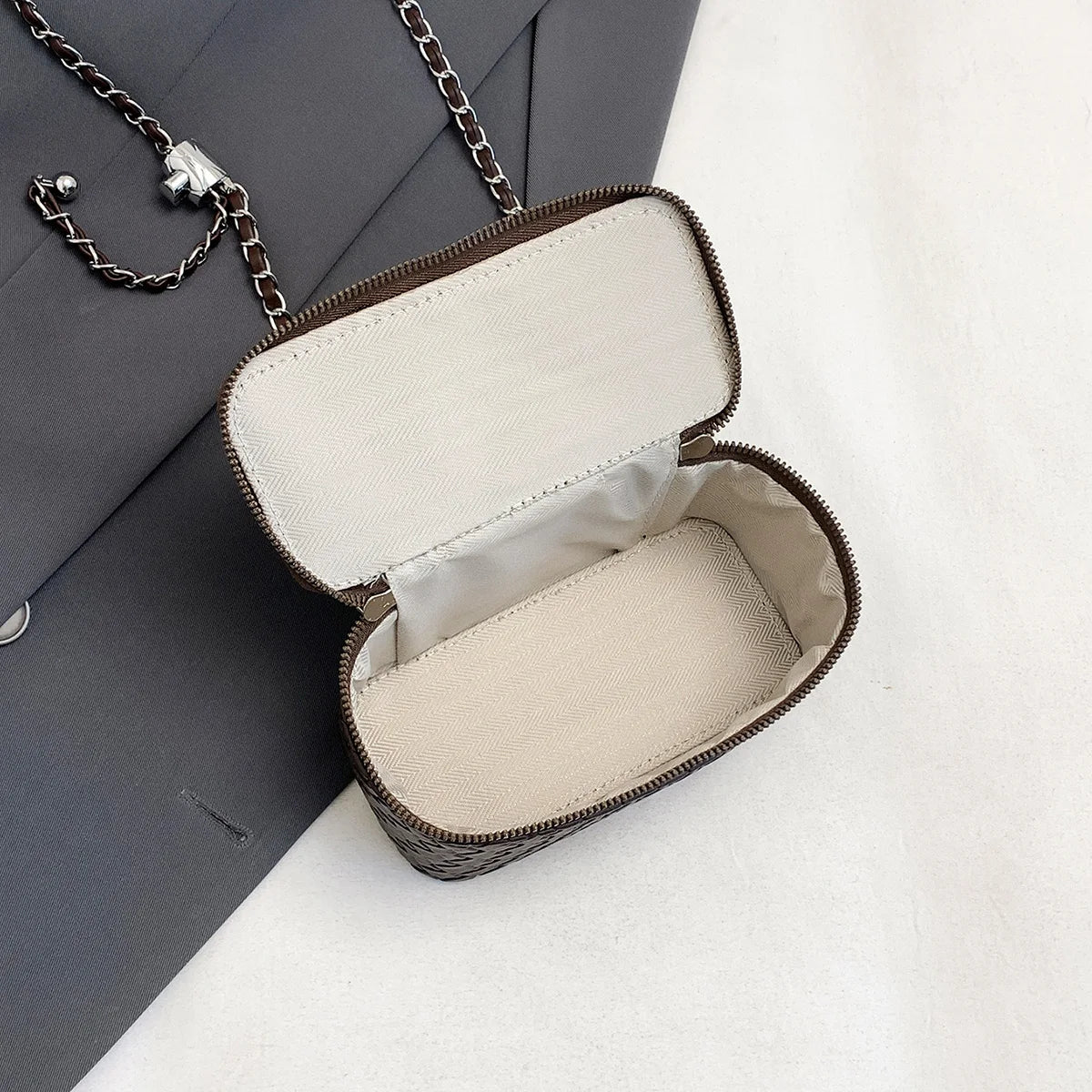 A vintage woven PU leather crossbody bag with a brown strap is shown open on a white surface.
