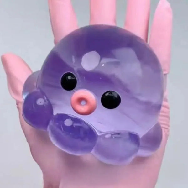 Durchsichtiger violetter Stressball in Form eines niedlichen, runden Tieres in der Hand.