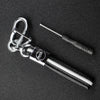 A silver key fob with a protective black TPU cover and a metal tool is displayed on a dark surface.