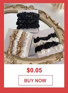 A close-up of a gold-framed display showing black and white ruffled fabric chains for a bohemian starfish and pearl bag acces