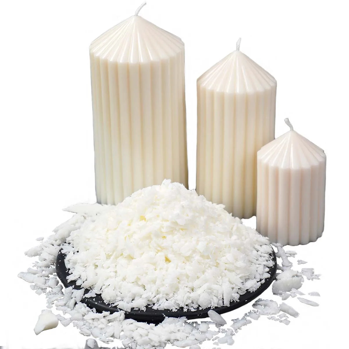 White natural soy wax flakes displayed next to two white pillar candles.