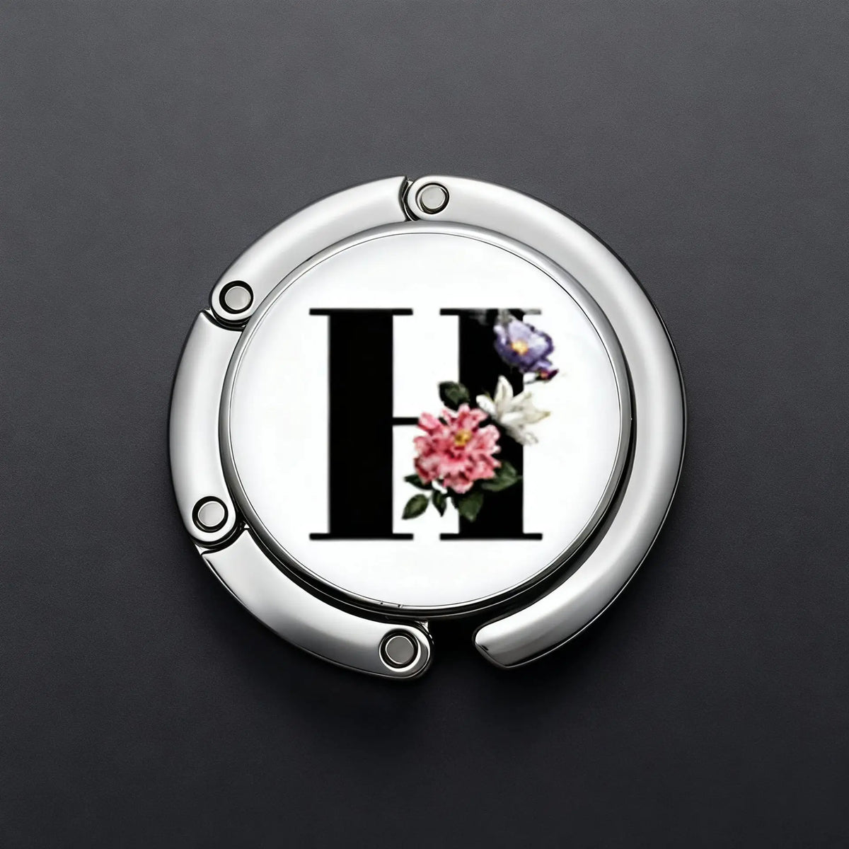 Silberner Briefhaken mit dem Buchstaben H und floralen Akzenten auf grauem Hintergrund