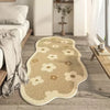 A beige irregular area rug with a subtle floral pattern is placed on a light wood floor next to a bed.