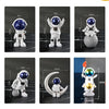 A collection of handcrafted astronaut figurines made of resin, displayed against a dark background.