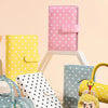 A collection of colorful polka dot storage books and wallets in pink, yellow, blue, and white.