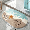 A beige and blue anti-slip bathroom rug featuring a starfish and heart design on a white marble floor.