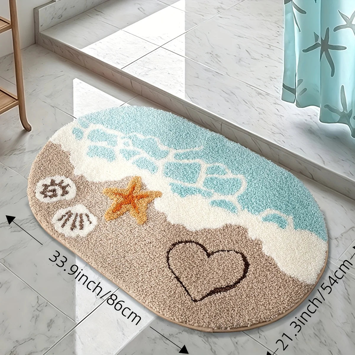 A beige and blue anti-slip bathroom rug featuring a starfish and heart design on a white marble floor.