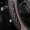 Close-up of a black quilted steering wheel cover with stitching and a zipper, showing controls.