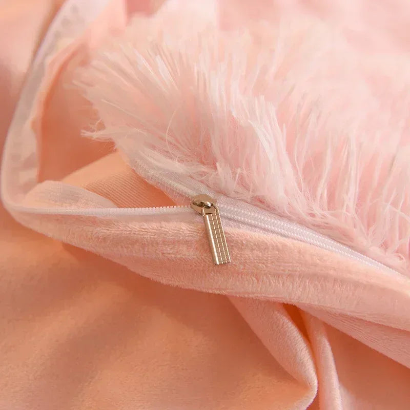 A close-up of a peach colored plush mink velvet duvet cover with a zipper and fluffy pink trim.