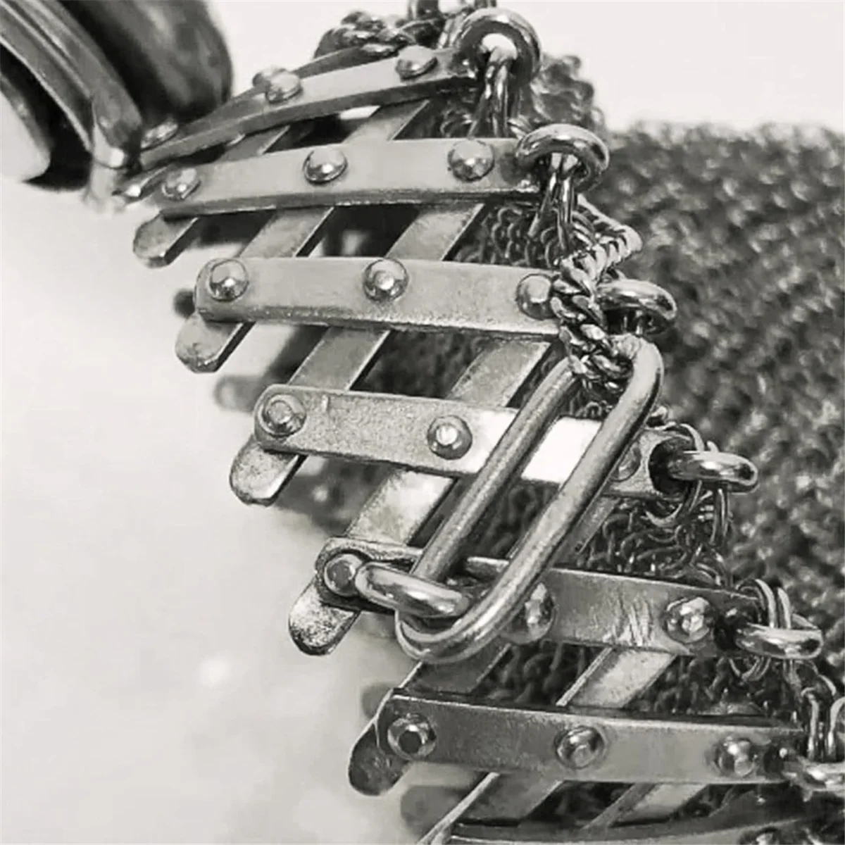 Close-up of a handcrafted stainless steel coin purse with a braided leather cord and metal detailing.