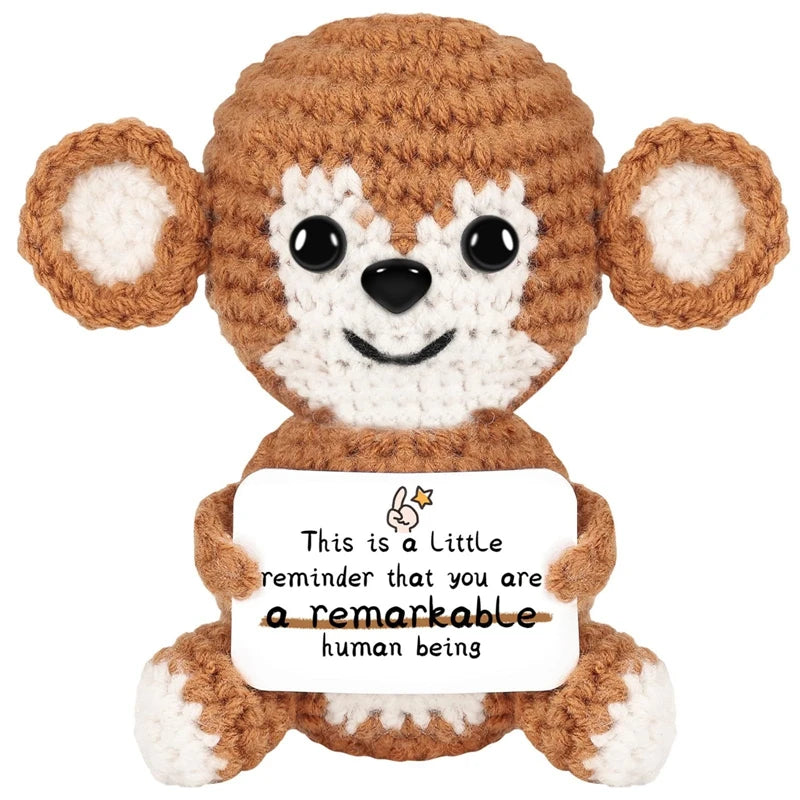 A handmade crochet brown animal doll with large ears and a white card that reads This is a little reminder that you are a rem