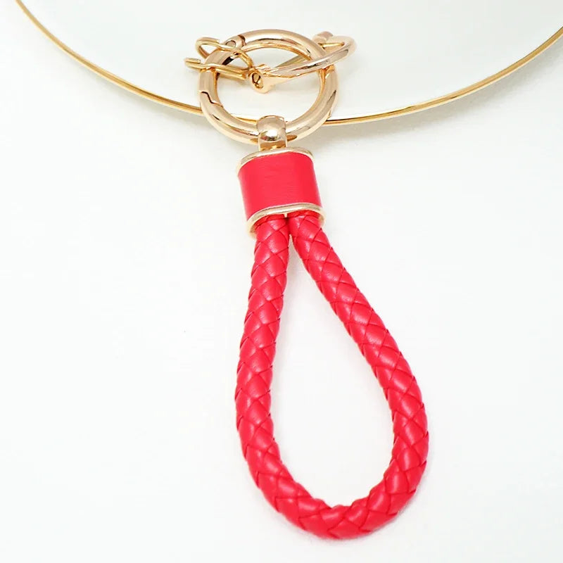 A red, braided leather key fob cover with a gold-toned metal clasp and chain.