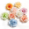 A collection of silk peony flower heads in shades of peach, yellow, pink, and blue.