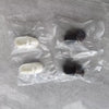 A clear plastic bag contains several articulated BJD collectible figurines in white and dark colors.