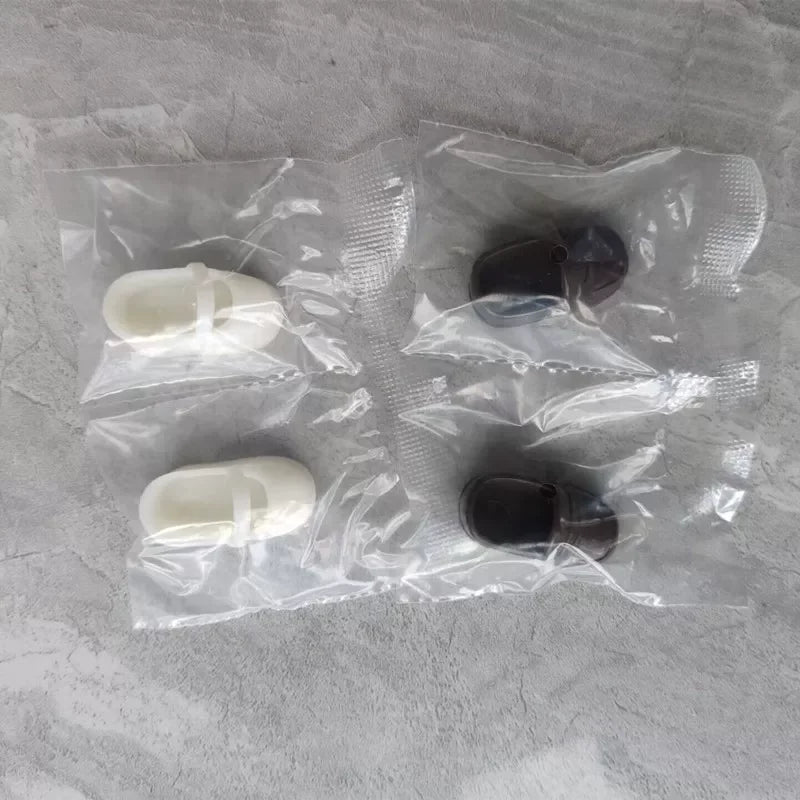 A clear plastic bag contains several articulated BJD collectible figurines in white and dark colors.