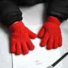 A pair of bright red, fuzzy plush winter gloves resting on lined paper.