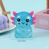 A bright blue axolotl squishy stress ball with pink accents resting on a light blue surface.