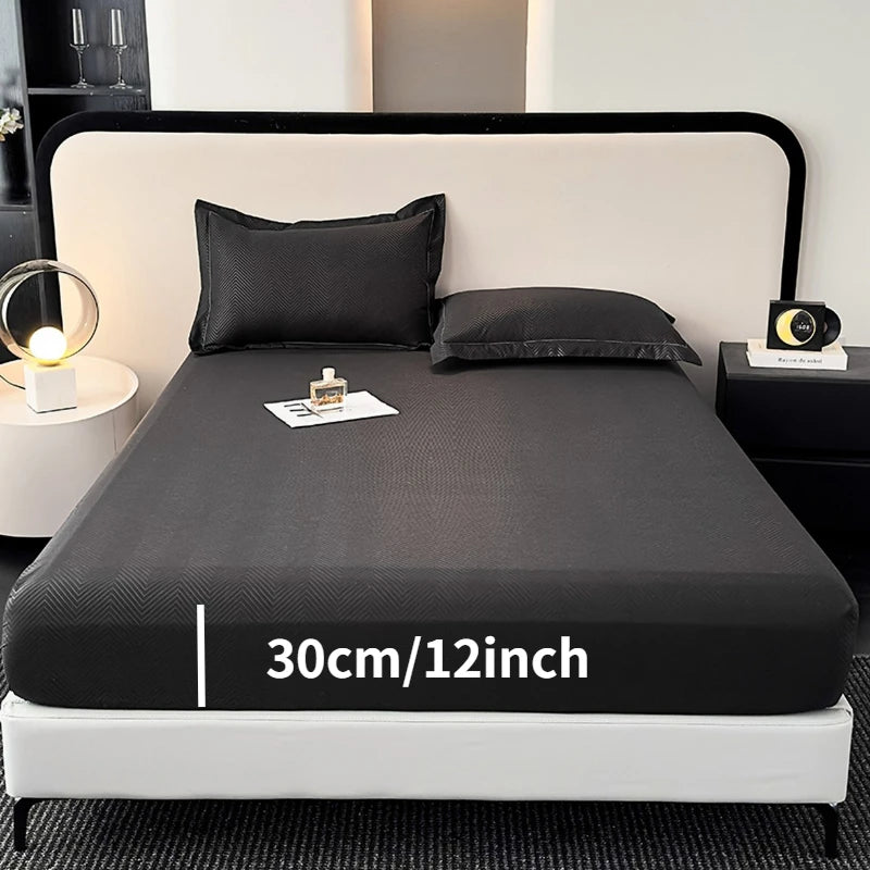 A black fitted sheet is displayed on a bed, showing the size 30cm/12inch.